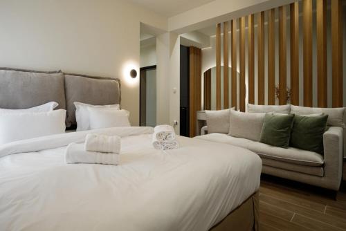 a bedroom with a large white bed and a couch at Olive City Suites in Larisa