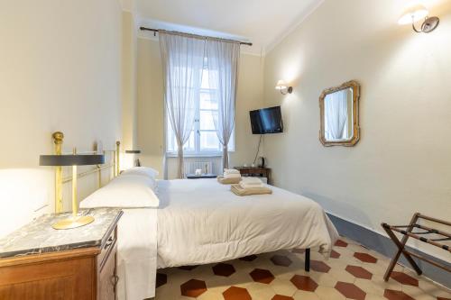 a bedroom with a large bed and a mirror at Lucca Charm in Lucca
