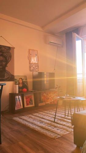 a living room with a table and a rug at Mimosa Apartments - City Center Square in Prishtinë