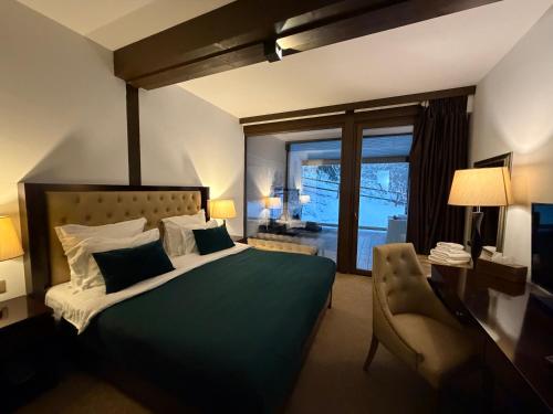 a bedroom with a large green bed and a chair at Alpine Lounge in Vatra Dornei