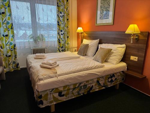 a bedroom with a bed with two towels on it at Hotel Formanka in Hustopeče