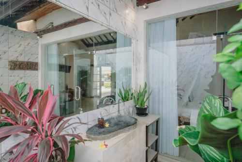 a bathroom with a sink and a large mirror at Frangipani Beach Hotel in Lovina