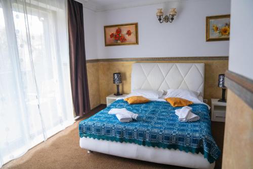 a bedroom with a bed with a blue comforter at Hanul Simonului in Bran