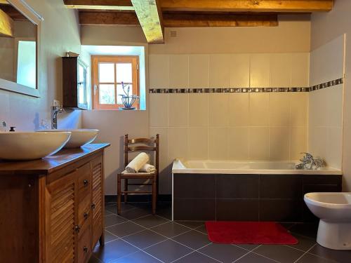 a bathroom with two sinks and a tub and a toilet at Le Gîte Escalletas in Arrens-Marsous