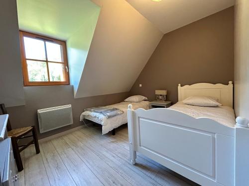a attic bedroom with two beds and a window at Le Gîte Escalletas in Arrens-Marsous