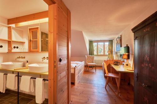 a bathroom with two sinks and a desk in a room at Hotel Oberstdorf in Oberstdorf