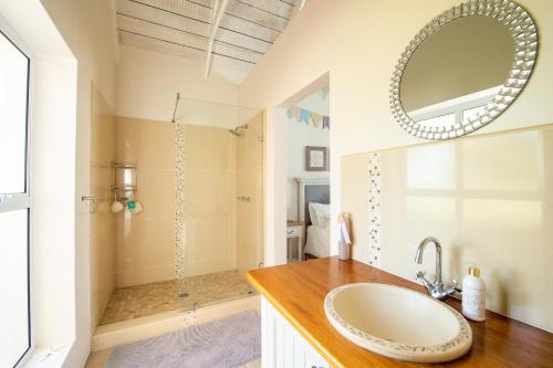 a bathroom with a sink and a shower at Beach House in Struisbaai