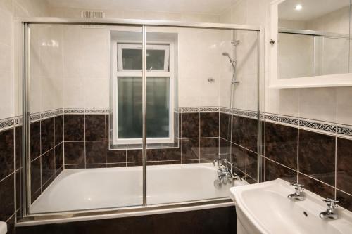 a bathroom with a tub and two sinks and a window at Evo Green Gravesend 2 bed Apartment, 2 mins Station, Town Centre in Gravesend