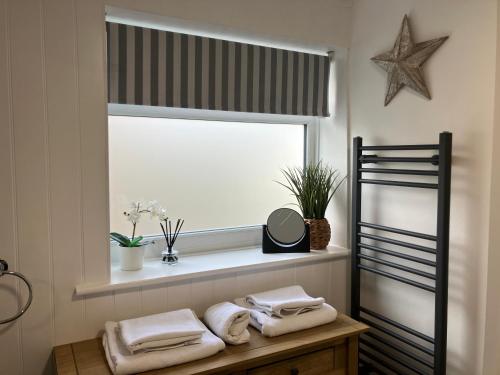 a window with towels on a table in a bathroom at Chestnut Cottage New Forest in Brockenhurst