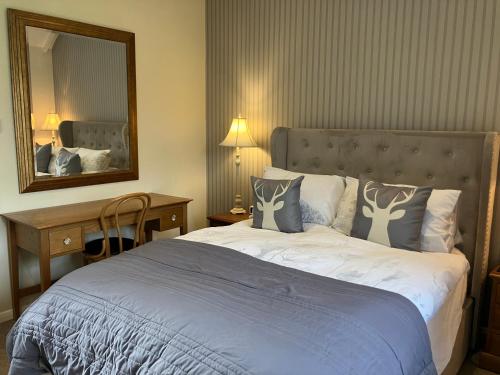 a bedroom with a large bed and a mirror at Chestnut Cottage New Forest in Brockenhurst