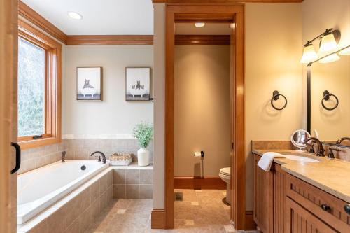 a bathroom with a tub and a sink at Headwaters Hideaway in Elk Park