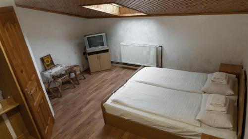 a bedroom with a white bed and a tv at Готель Меридіан in Yasinya