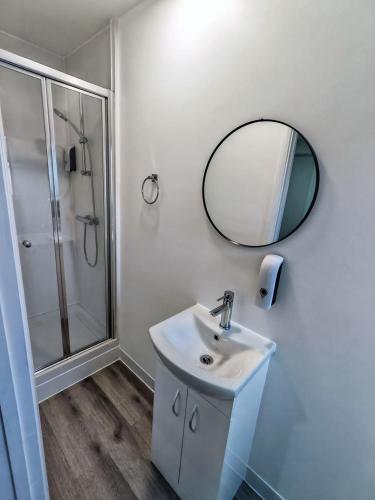 a white bathroom with a sink and a mirror at Rose Studio - Self Contained Studio Flat in Oxford