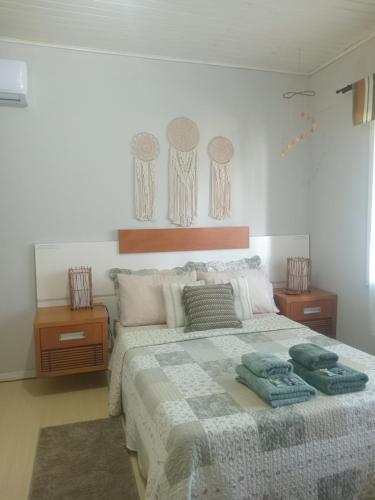 a bedroom with a large bed with two night stands at Casa Verde do Lago in São Francisco de Paula