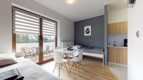 a bedroom with a bed and a table and chairs at Apartament Fibra Crema in Rybnik