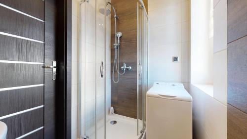 a bathroom with a shower and a toilet and a sink at Apartament Fibra Crema in Rybnik