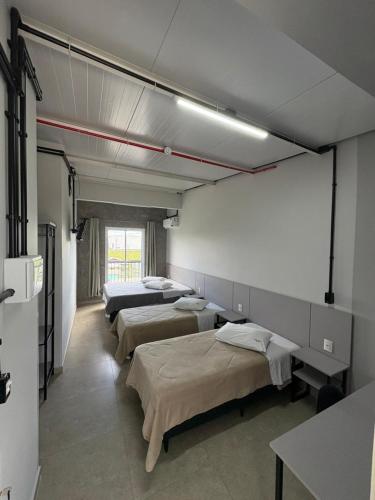 a room with three beds in a room at Sierra Lages Hotel in Lages