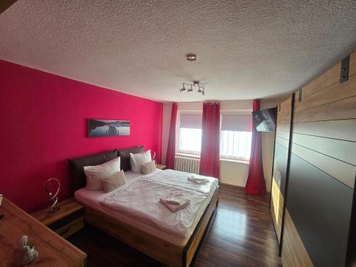 a room with a bed with a pink wall at Ferienwohnung, Apartment, Monteurwohnung mit Klimaanlage Wettin-Löbejün in Gottgau