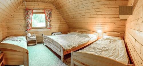 a bedroom with two beds in a log cabin at Chata Malino in Ružomberok