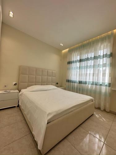 a bedroom with a large white bed and a window at Valamar Residence Apartment with balcony in Draç