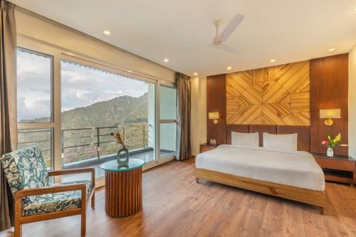 a bedroom with a bed and a large window at Country Inn Premier Pacific Mall Road Mussoorie in Mussoorie