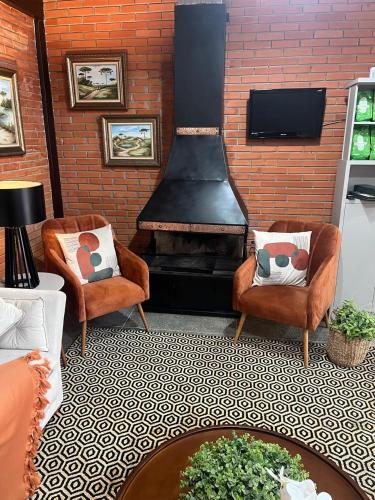ein Wohnzimmer mit zwei Sesseln und einem Kamin in der Unterkunft Hotel Blumenpark in Rio Negro