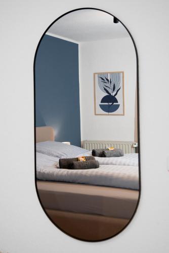 a mirror reflecting a bedroom with a bed at Quartier VierGlück in Marl