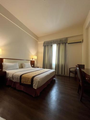 a hotel room with a bed and a window at Atari Inn Tawau in Tawau