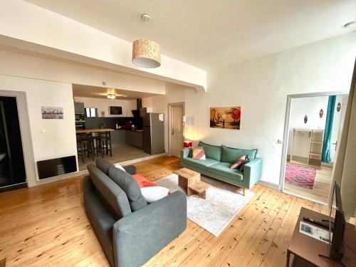 a living room with a couch and a table at Louisa - Spacieux en Plein centre - Places gratuites - 1er étage in Auch