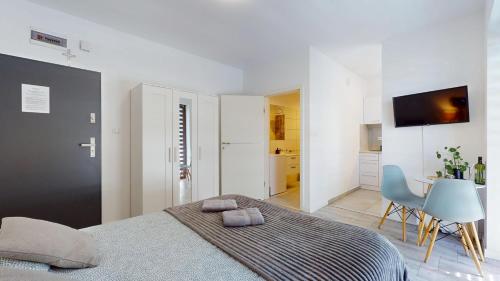 a bedroom with a bed and a table and a chair at Studio Fibra Macchiato in Rybnik