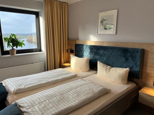a hotel room with two beds and a window at Hotel Brückentor in Rinteln