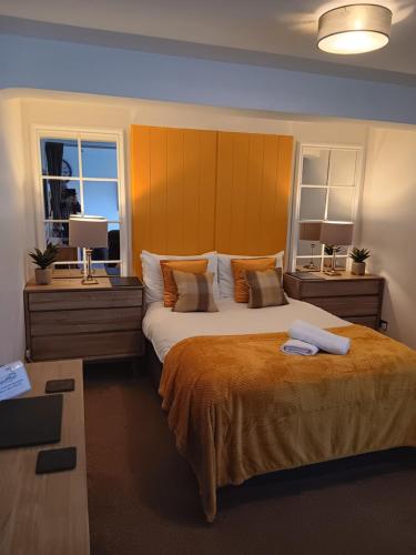 a bedroom with a large bed and two windows at The Studio in Windermere
