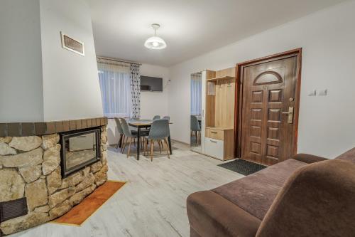 a living room with a couch and a fireplace at Domki Nad Tanwią in Susiec