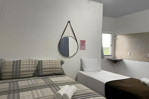 a bedroom with two beds and a mirror on the wall at Apartamentos Vitória – Conforto e Excelente Localização in Barreirinhas