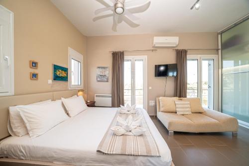a bedroom with a large white bed and a couch at Villa Sorina Kefalonia in Svoronata
