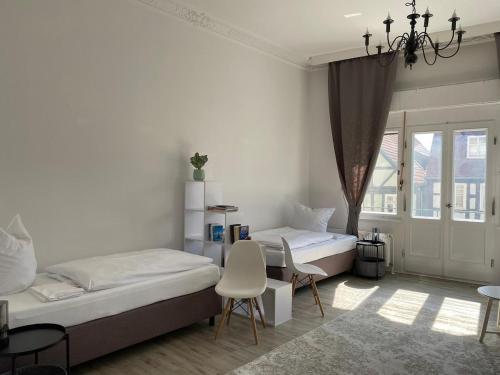 a bedroom with two beds and a table and chairs at Das MONTI - Superior in Stendal