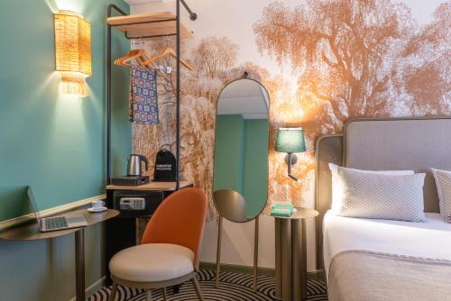 a hotel room with a bed and a mirror at Hotel Avalon Paris Gare du Nord in Paris