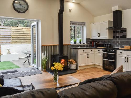 a kitchen and living room with a stove at Perthi Bach in Porthmadog