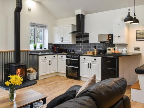 a kitchen with a couch and a stove at Perthi Bach in Porthmadog
