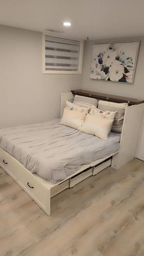 a large white bed in a room with wooden floors at Cozy East Hill 2026 in Belleville