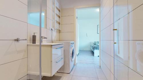 a white laundry room with a washer and dryer at Studio Fibra Barista in Rybnik