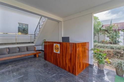 a living room with a couch and a podium with a television at Itsy Hotels Jammabane Cottage, 5 Minutes To Mountain View Coffee Plantation in Madikeri