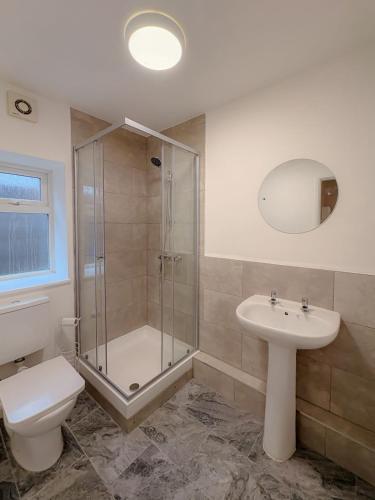 a bathroom with a shower and a toilet and a sink at 58c Thorpe Road - City Centre in Norwich