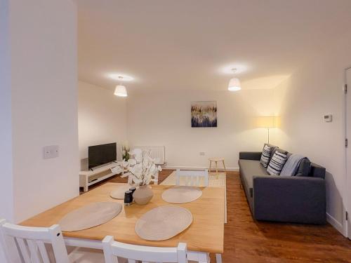a living room with a couch and a table at 58c Thorpe Road - City Centre in Norwich
