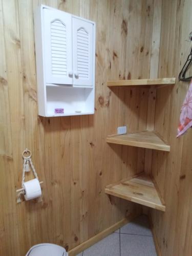 a bathroom with wooden walls and a toilet paper dispenser at Casa Hostal Familiar Espacio SaTaNaMa in El Torreón