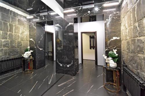 a room with black marble walls and a hallway at Апарт-отель ЛЕВЕЛ Ереван, Ханджян 47 in Yerevan