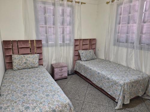 a bedroom with two beds and a window at Villa appartement jardin et piscine in Meknès