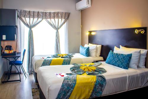 a hotel room with two beds and a window at Scenery Maqalika Guesthouse in Maseru