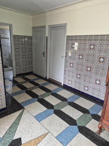 a room with a checkered tile floor and a door at Villa appartement jardin et piscine in Meknès