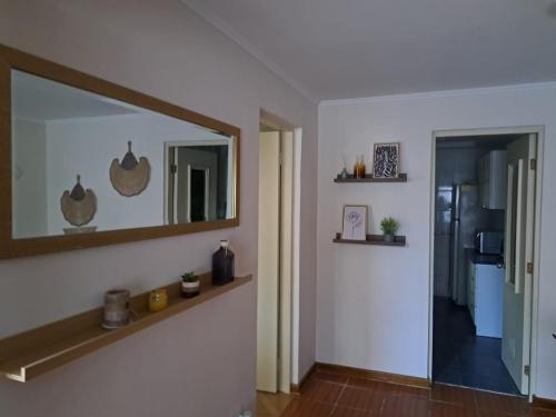 a living room with a mirror and a hallway at Acogedora casa para 6 personas en algarrobo in Algarrobo